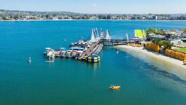 A marina with boats, a bridge, and a beach area.
