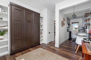 Cozinha moderna com área de refeições, piso de madeira e um guarda-roupa espaçoso.