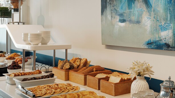 A buffet with various food items and a painting on the wall. - Mia Hotels Agadir (Agadir)