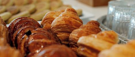 A variety of pastries, including croissants and other baked goods, displayed on a table.