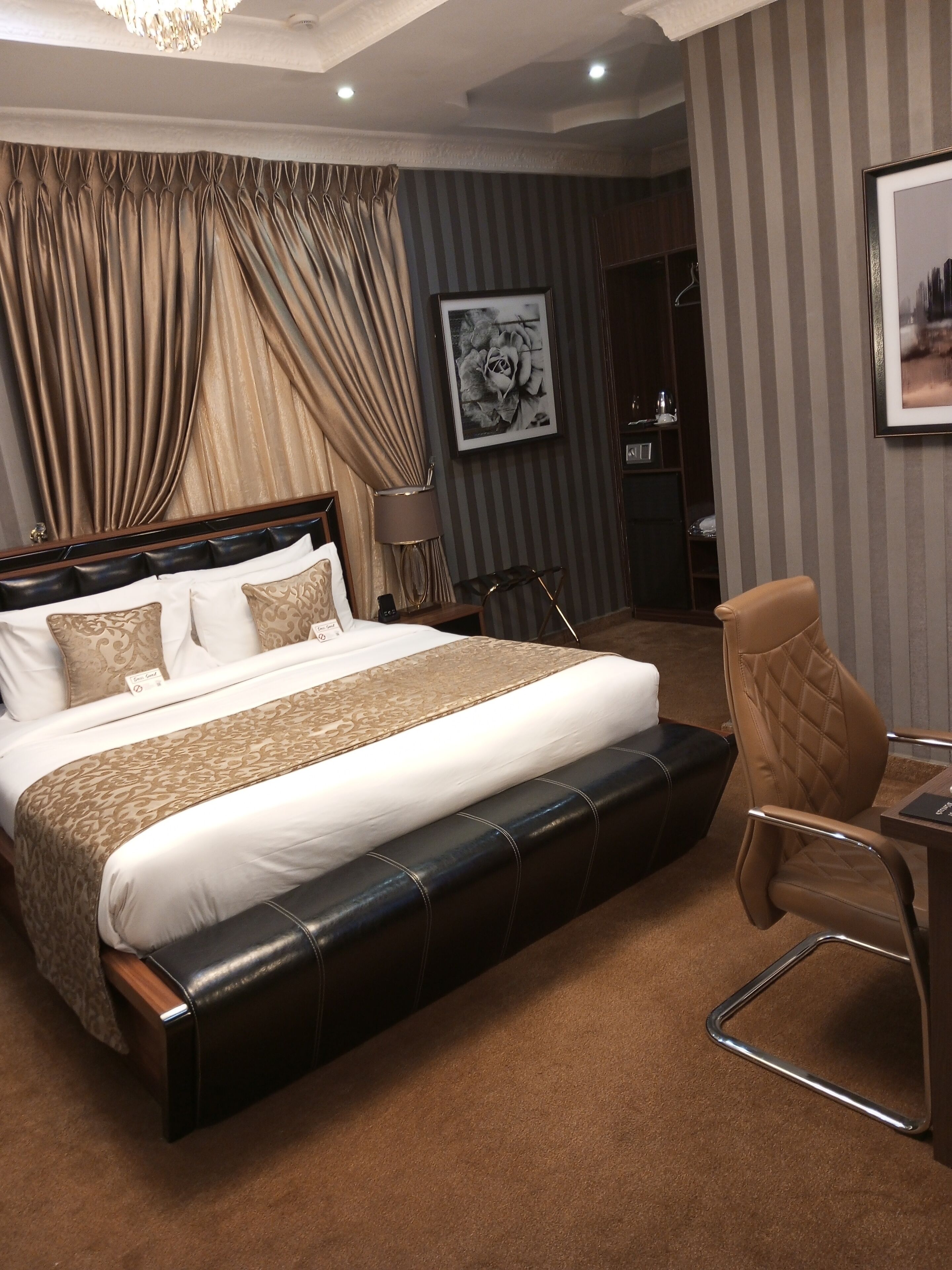 A bedroom with a large bed, a desk, and a chair.