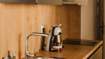 A modern kitchen with a stainless steel sink, wooden countertop, and a built-in microwave.