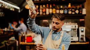Un bartender sirviendo una bebida en un vaso.