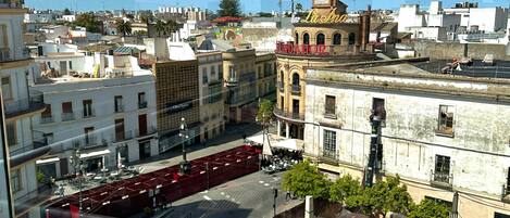 A cityscape with a view of buildings, a street, and a parked car.