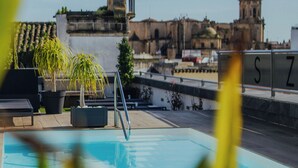Una piscina con vistas a edificios históricos al fondo.