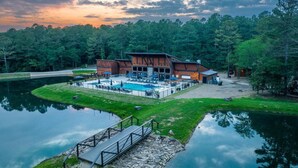 A lakeside lodge with a swimming pool, outdoor seating, and a dock. - Custom Cabin w/ Games, Karaoke, Amazing Outdoor patio w/ swings - Sleeps 12 (Broken Bow)