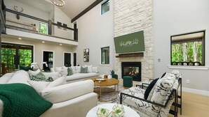 A spacious living area with a fireplace, a sofa set, and a coffee table. - Custom Cabin w/ Games, Karaoke, Amazing Outdoor patio w/ swings - Sleeps 12 (Broken Bow)