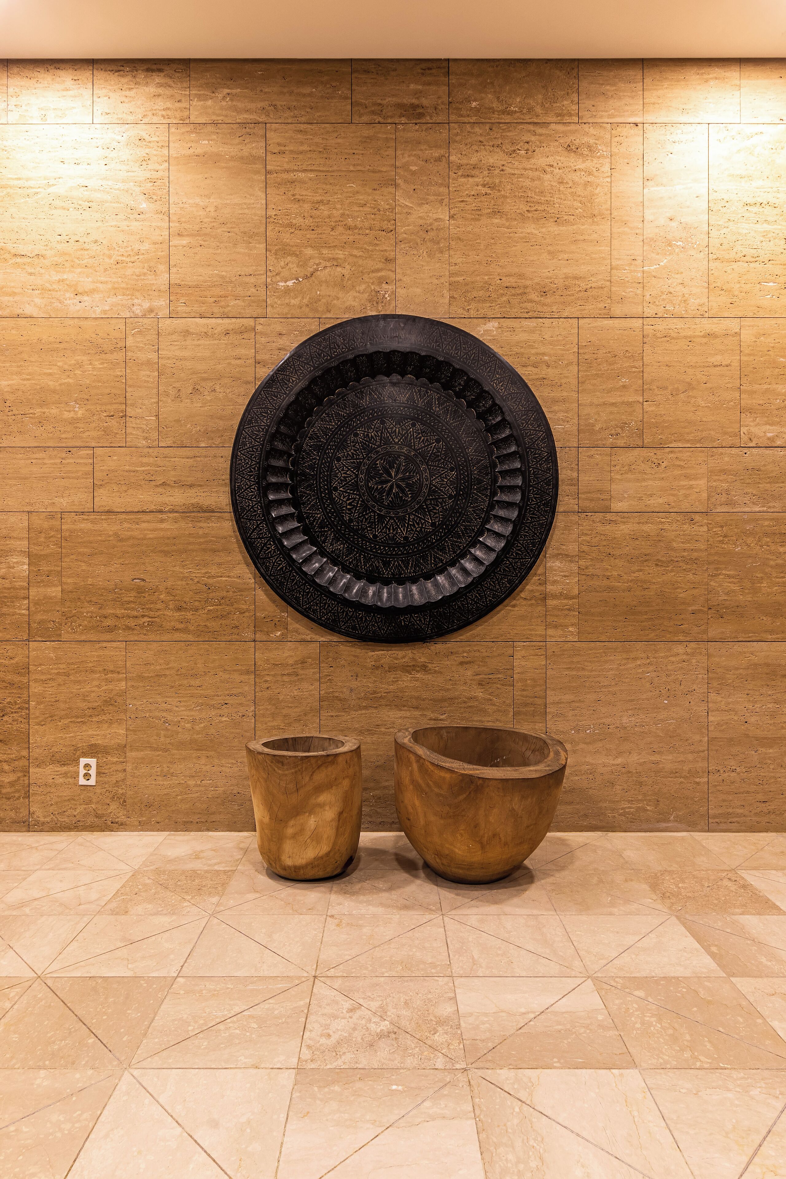 A wall-mounted decorative plate with two wooden bowls below it.