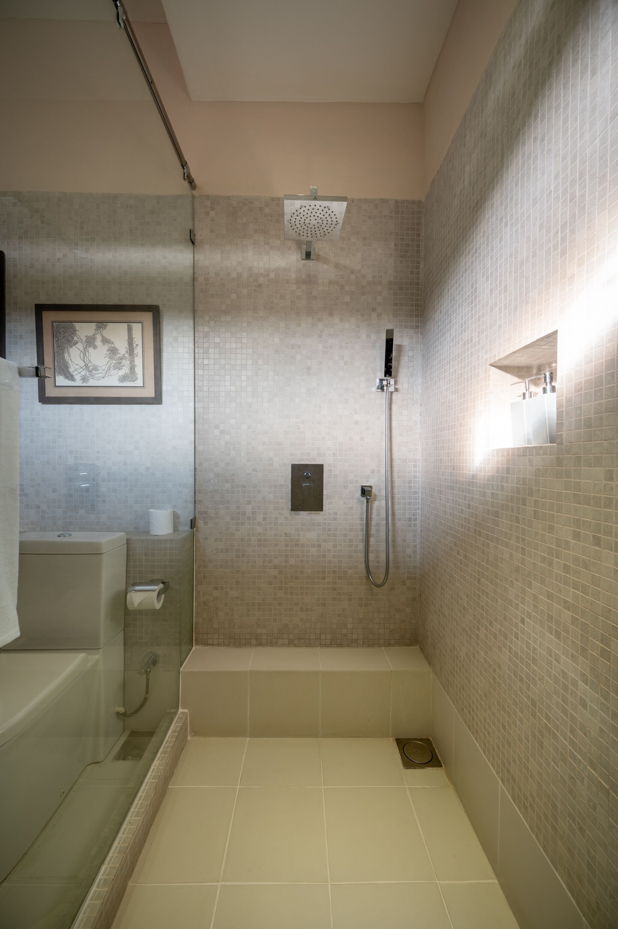 A modern bathroom with a shower, a toilet, and a sink.