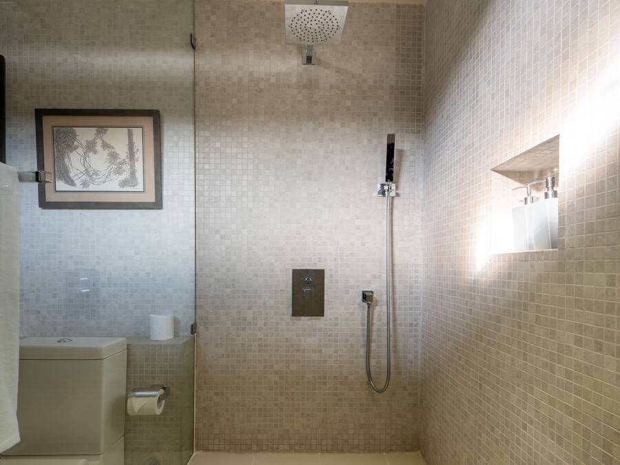 A modern bathroom with a shower, a toilet, and a sink.