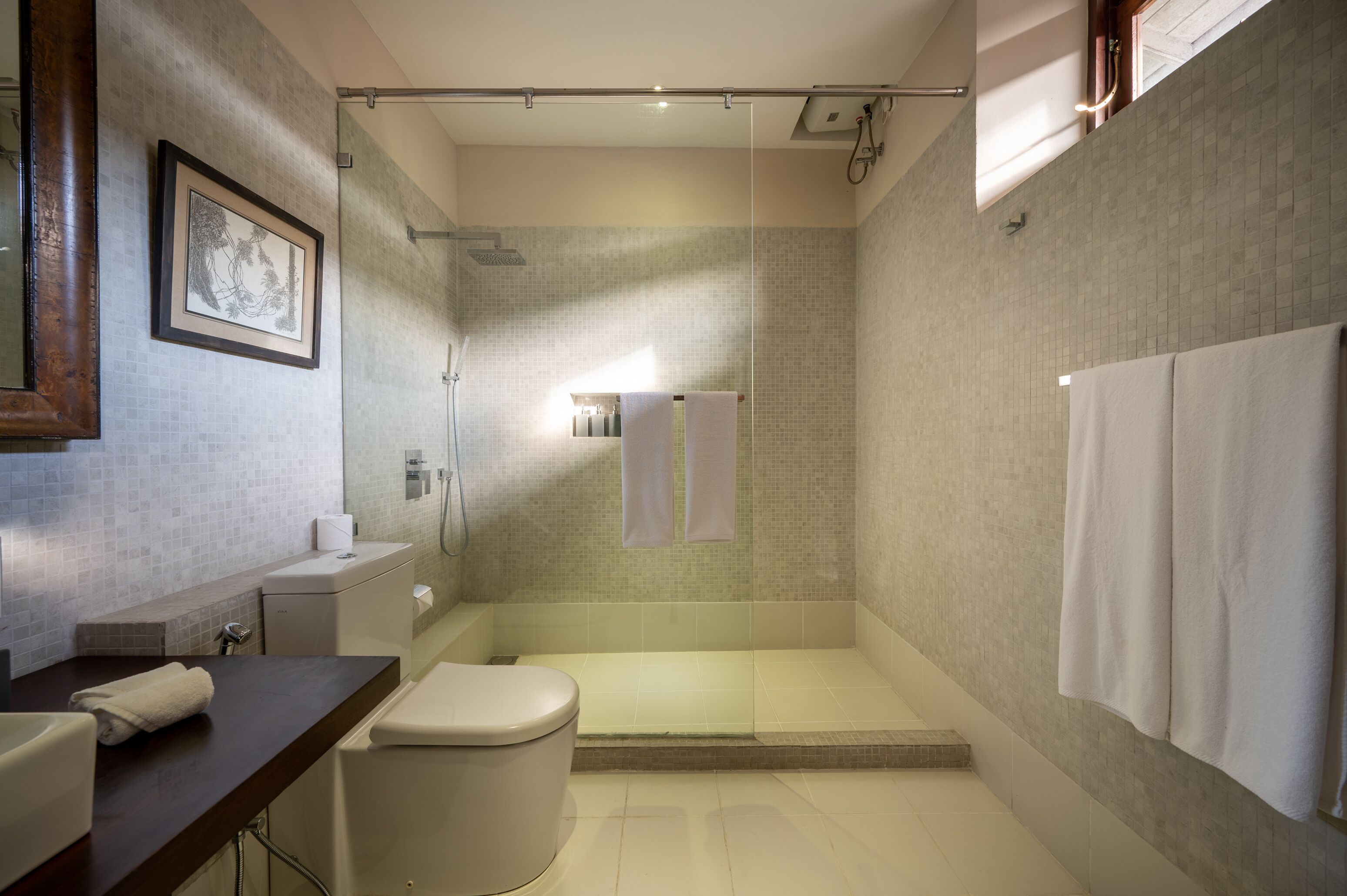 Un bagno moderno con doccia, servizi igienici e lavandino.
