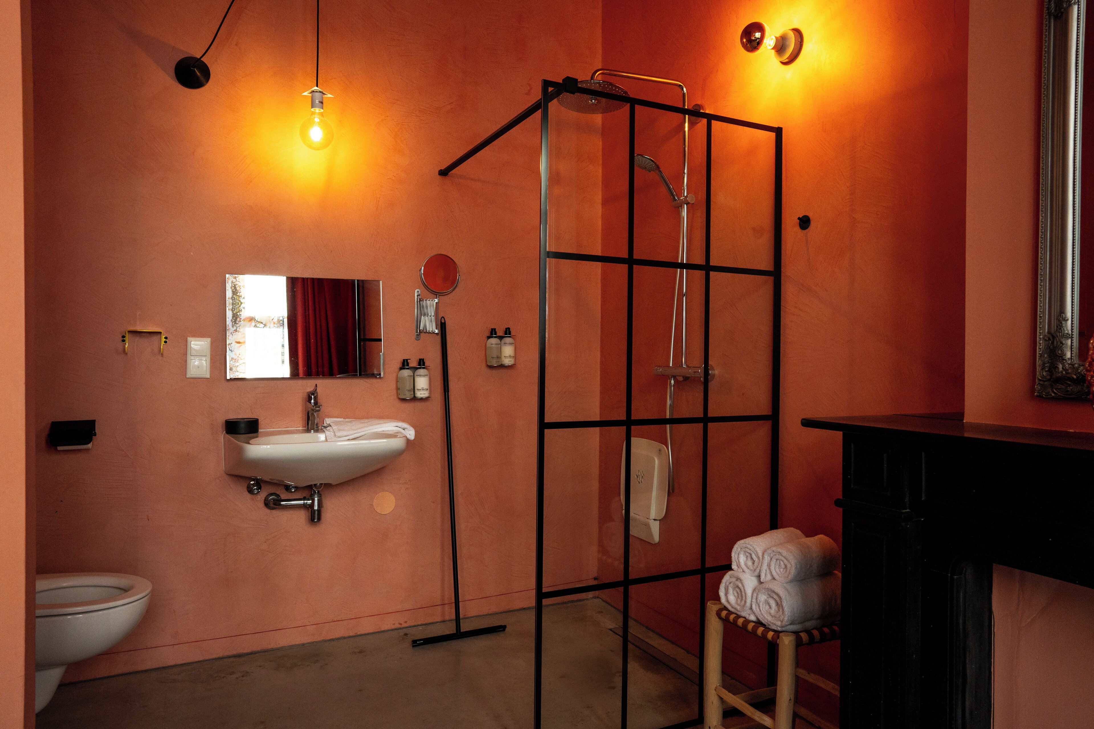 Un baño con ducha de vidrio, lavabo, inodoro y espejo.