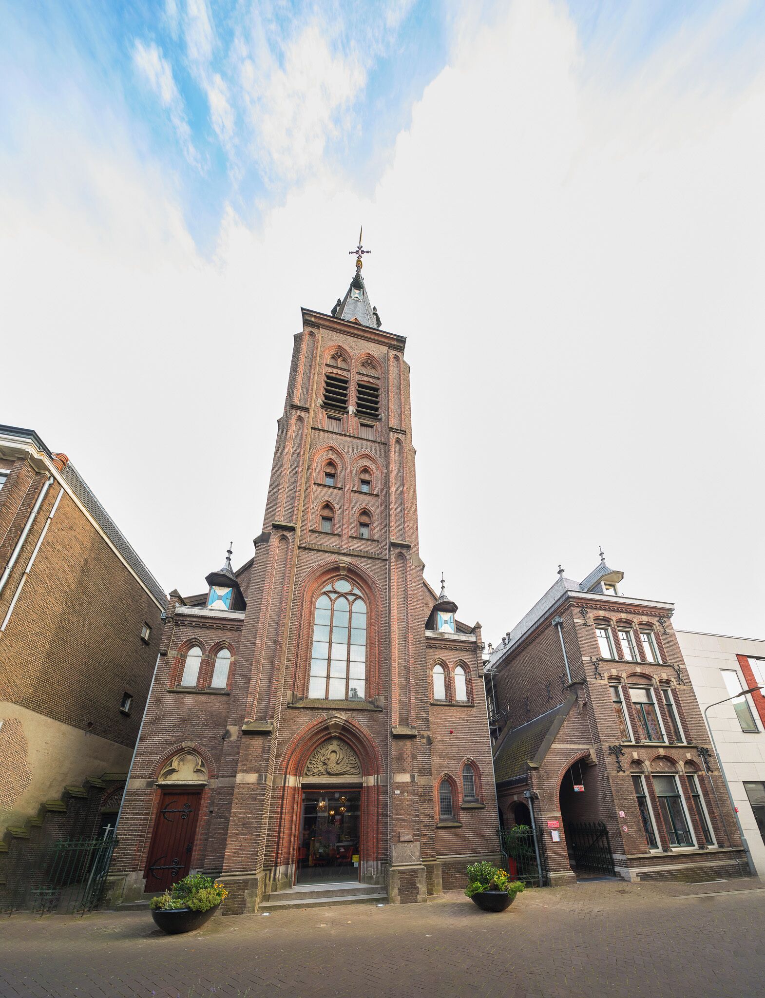 A historic church with a tall central tower, large arched windows, and a prominent entrance.