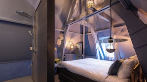 Ein Schlafzimmer mit Bett, Dusche und einer Pendelleuchte.