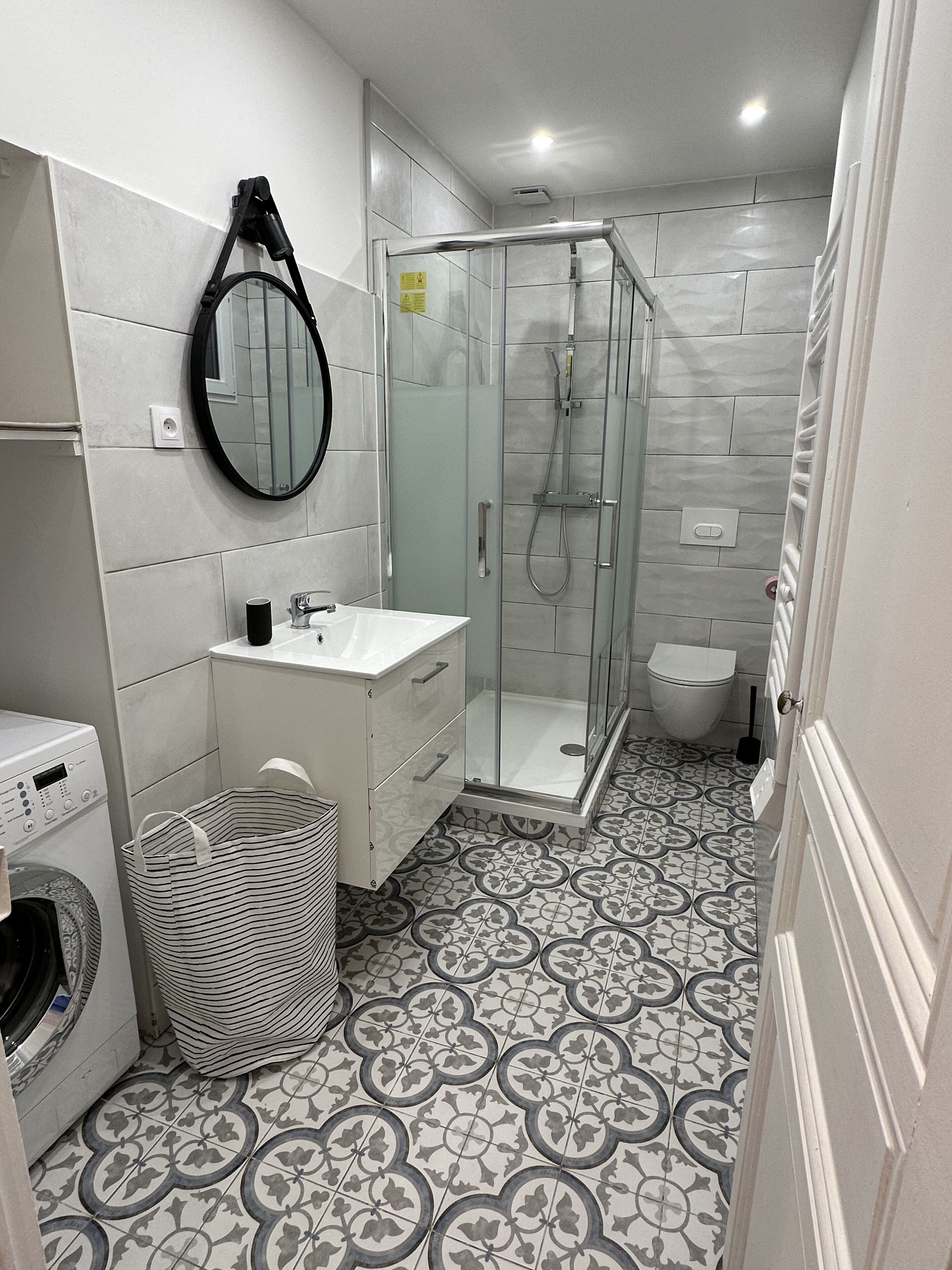 A modern bathroom with a shower, toilet, and sink.