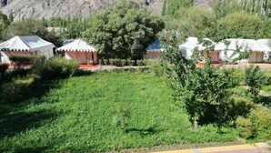 Una hilera de yurtas con techos blancos y rojos, con montañas al fondo.