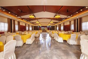 A banquet hall with rows of tables and chairs, a high ceiling with chandeliers, and a central aisle. - Yuzhong Baguo Hotel (Langzhong)