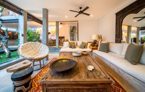 Relax in this stylish living room with a sofa, coffee table, and large mirror.