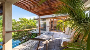 A covered outdoor seating area with a pool in the background. - Stunning 4BR Private Villa in Canggu (Canggu)