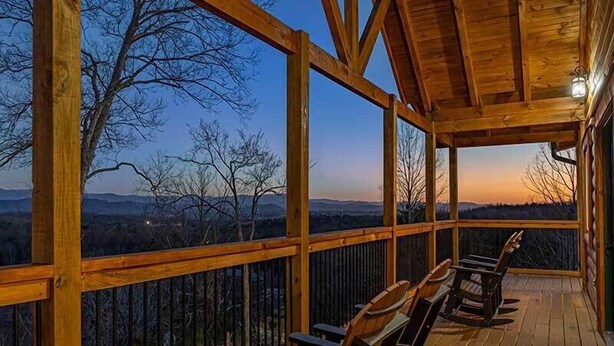 Une terrasse en bois offrant une vue sur un paysage montagneux.