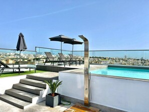 Un espace piscine sur le toit offrant une vue dégagée sur le paysage urbain, un sol chauffé et une piscine d’une profondeur de 1,2 mètre.