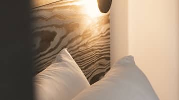 Una cama con cabecera de madera y almohada blanca.