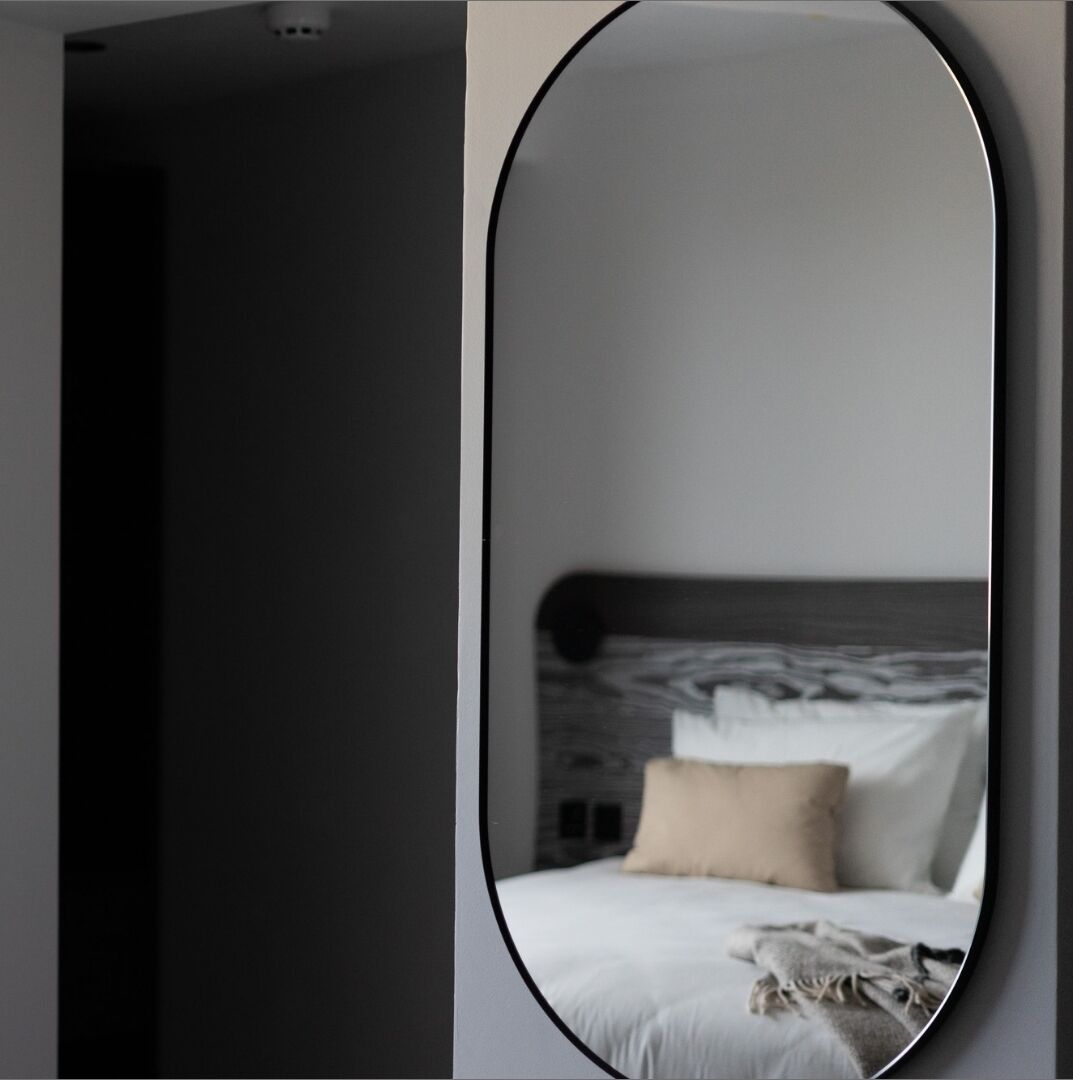 Un dormitorio con cama, almohadas y manta.