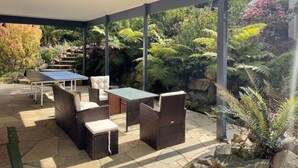 An outdoor patio with wicker furniture, a ping pong table, and a covered area. - Large Cottage - Heart of Olinda - Old Police station (Olinda)