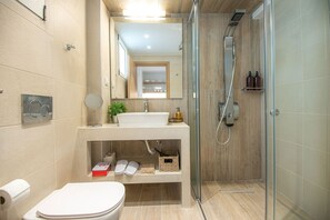 Une salle de bain moderne avec une douche à parois de verre, un lavabo blanc et des toilettes.