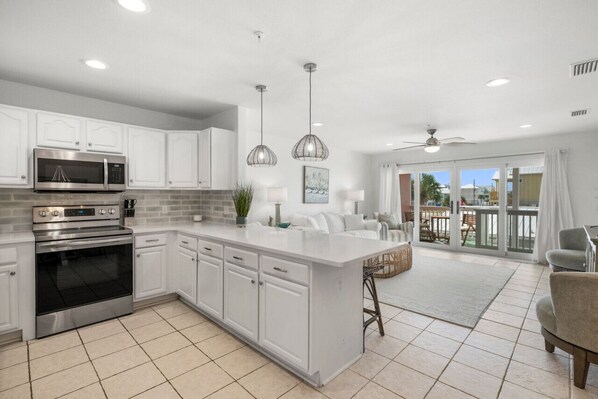 Enjoy cooking in this well-equipped kitchen with a large island, sink, and stainless steel appliances.
