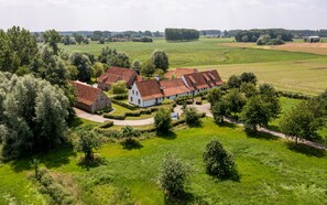 A large estate with multiple buildings, expansive green fields, and a well-maintained garden.