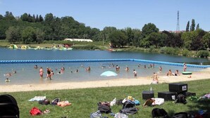 A swimming pool surrounded by grassy areas with people swimming and sunbathing. - 2-bedroom apartment at the foot of the Pyrenees (Pointis-de-Rivière)