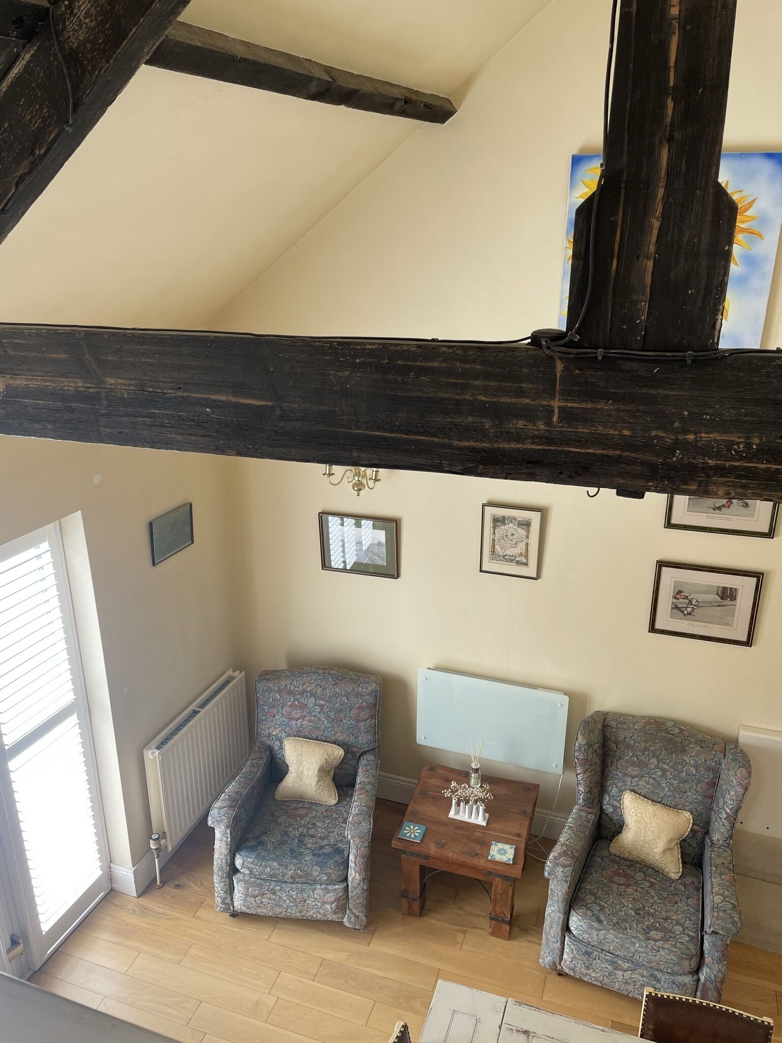 A cozy living room with two armchairs, a small table, and a radiator.