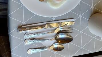 A plate of breakfast food including bacon, eggs, beans, and toast on a table with a geometric patterned tablecloth.