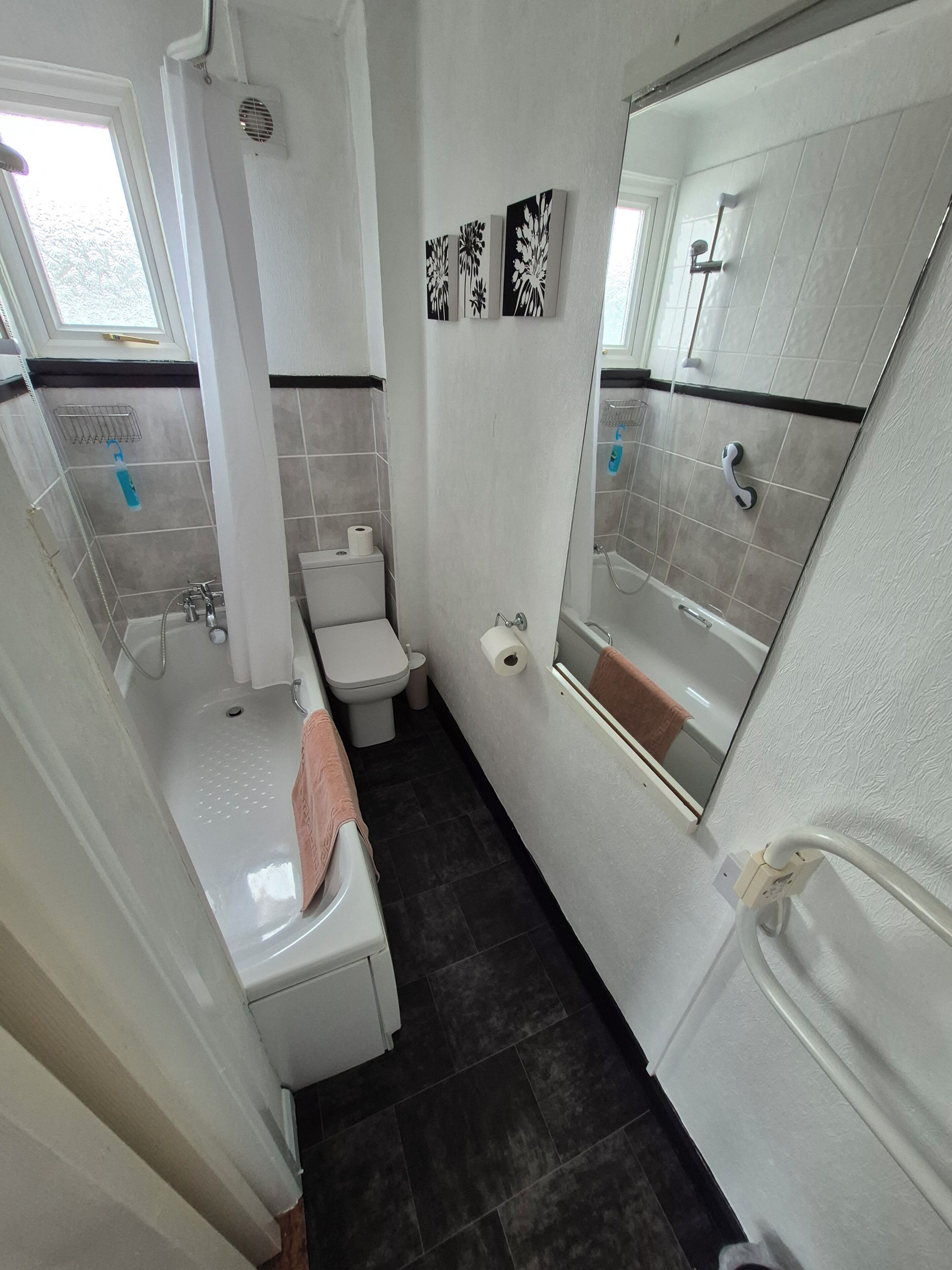 A compact bathroom with a bathtub, toilet, and shower.