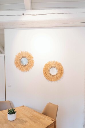 Simple, functional space with a dining table, chairs, and wall art.
