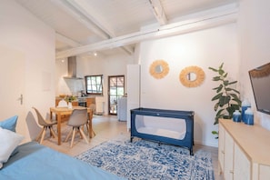 Relax in this stylish space with a large bed, dining area, and modern bathtub.