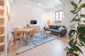 Relax in this stylish living space with a dining table, sofa, and flat-screen TV.