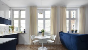 Una cocina moderna con una mesa redonda, sillas blancas y un sofá azul.