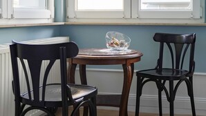 A dining area with two black chairs, a round wooden table, and a glass bowl on the table. - Seebad Ahlbeck - spacious apartment with sea view close to the beach (Heringsdorf)