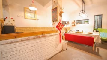 A restaurant with a brick wall, a red table, and a hanging light fixture.
