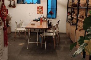 Un coin repas avec une table en bois, des chaises et une fenêtre.