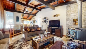 A cozy living room with a fireplace, a television, and a sofa. - Mountain Modern Townhome, Natural Light, Near The Village, On-Site Pool (Mammoth Lakes)