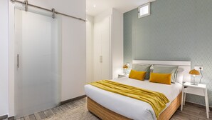 Een moderne slaapkamer met een bed, nachtkastjes en een kledingkast.