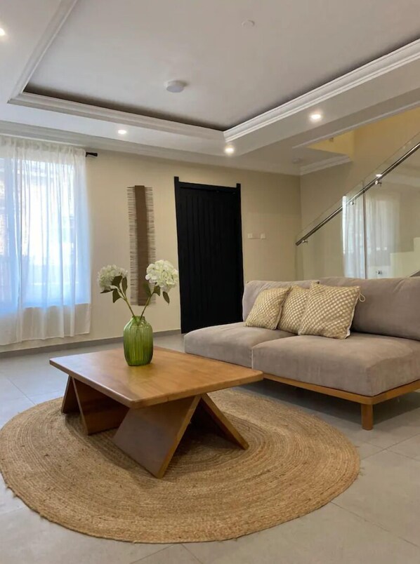 A modern living room with a sofa, a coffee table, and a decorative vase.