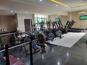 A gym with various exercise equipment including treadmills, stationary bikes, and weight machines.