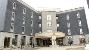 A large, modern hotel with a central entrance, multiple floors, and a stone facade. - Candellux Imperial Hotel and Suites (Abuja)