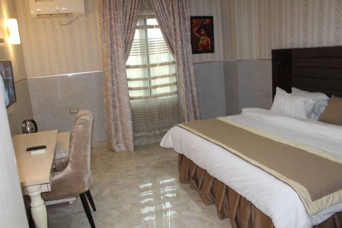 Een hotelkamer met een bed, een bureau en een stoel.