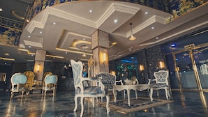 A luxurious lobby with ornate chairs, a grand ceiling, and a bar area. - Candellux Imperial Hotel and Suites (Abuja)
