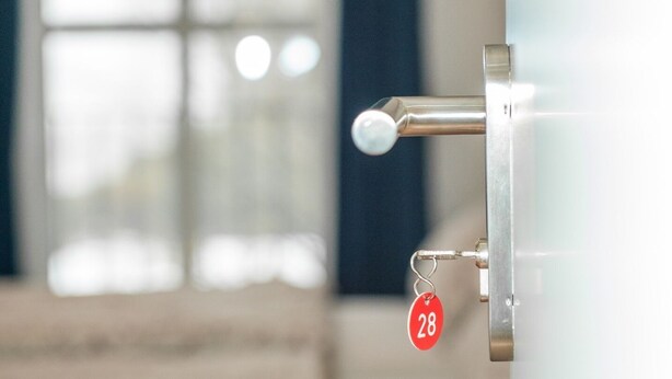 Une vue rapprochée d’une serrure de porte, avec un trou de serrure et une étiquette rouge portant le numéro 28.